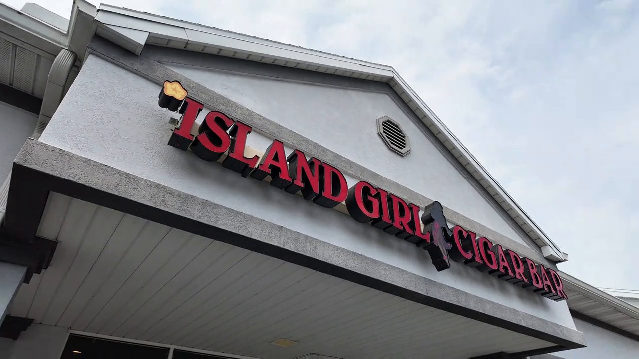 The Island Girl Cigar Bar sign over the entrance of a strip mall storefront.